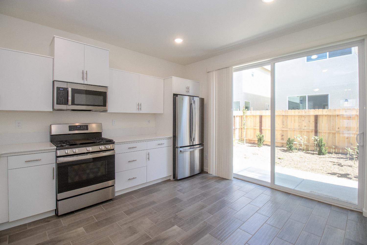 512 Pioneer Lane Clovis, CA 93619 - Photo 5 of 17 a kitchen with a stove a microwave and a refrigerator