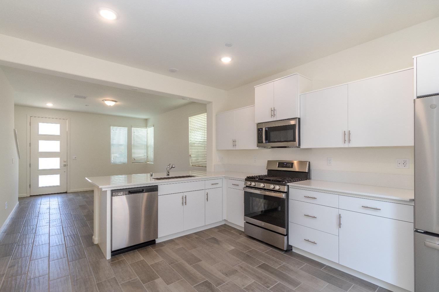 512 Pioneer Lane Clovis, CA 93619 - Photo 6 of 17 a kitchen with granite countertop stainless steel appliances a sink cabinets and a window