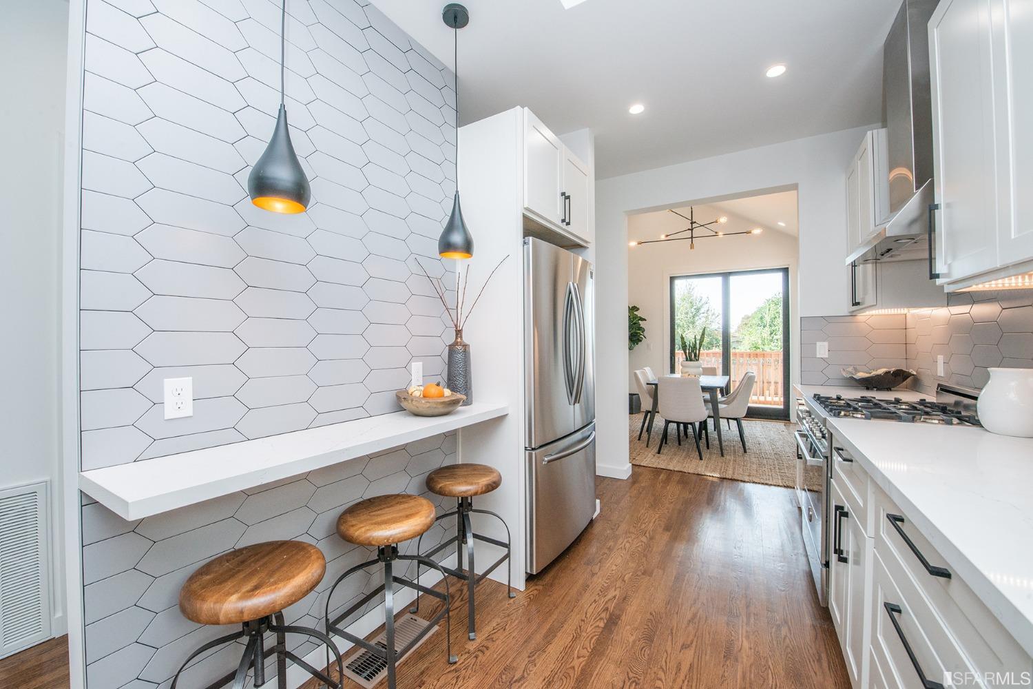 2422 Bonar Street Berkeley, CA 94702 - Photo 15 of 54 a kitchen with stainless steel appliances a stove a refrigerator a dining table and chairs with wooden floor