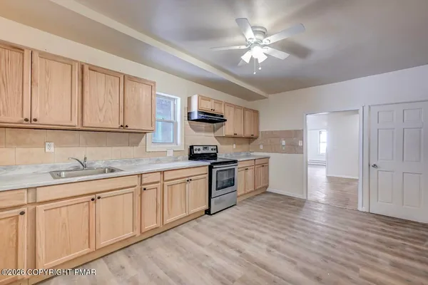 a kitchen with stainless steel appliances granite countertop a stove sink and cabinets