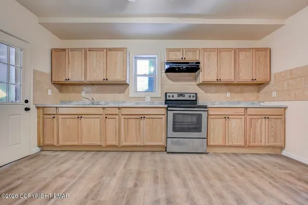 a kitchen with granite countertop a stove top oven a sink dishwasher and a refrigerator with wooden floor