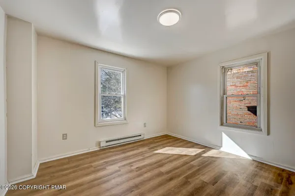 an empty room with wooden floor and closet