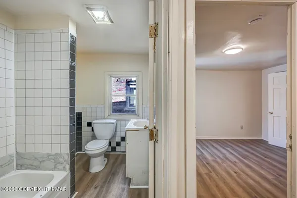 a white toilet sitting next to a bath tub and a shower