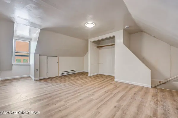 a view of empty room with wooden floor