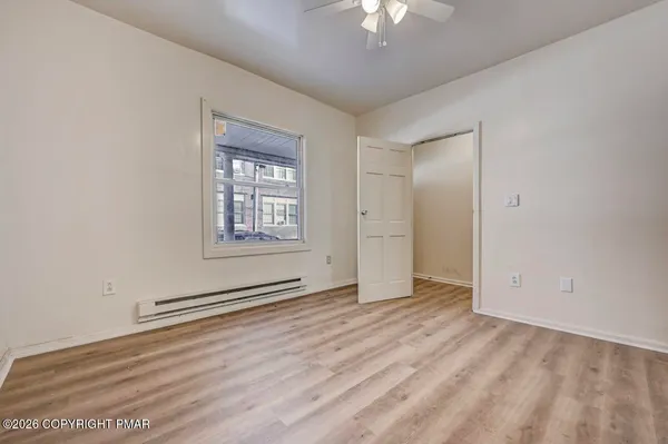 an empty room with wooden floor and closet