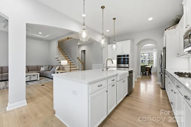 a large kitchen with stainless steel appliances kitchen island granite countertop a large island a stove a sink a dining table and chairs