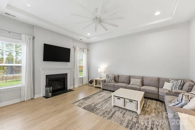 a living room with furniture a fireplace and a flat screen tv