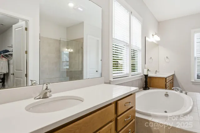 a bathroom with a granite countertop sink and a large mirror