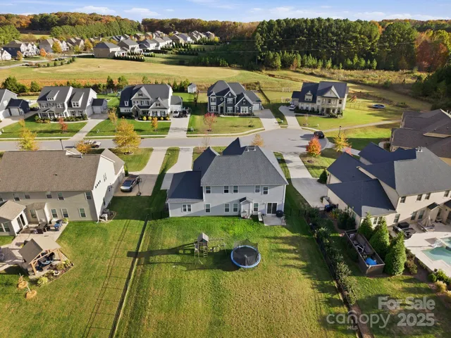 an aerial view of a house with swimming pool and lake view