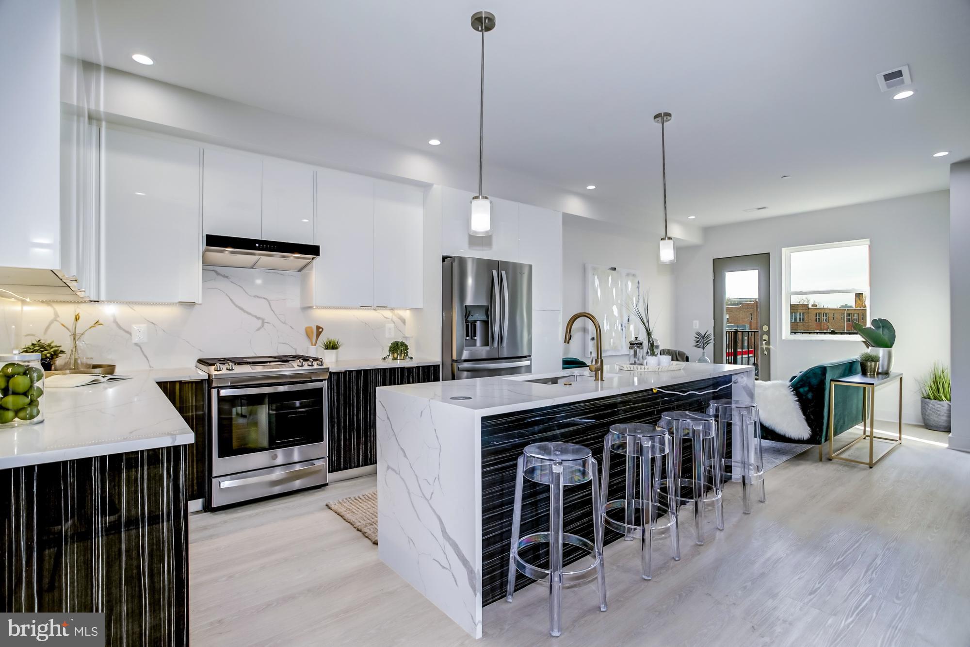 a kitchen with kitchen island granite countertop a stove a sink a dining table and chairs