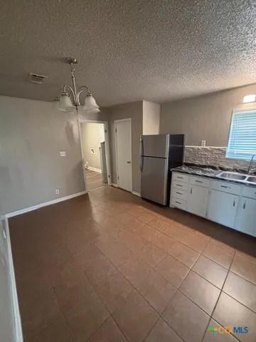 a large kitchen with a stove a refrigerator and a sink