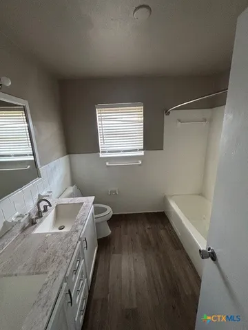 a bathroom with a bathtub a sink a toilet and a mirror