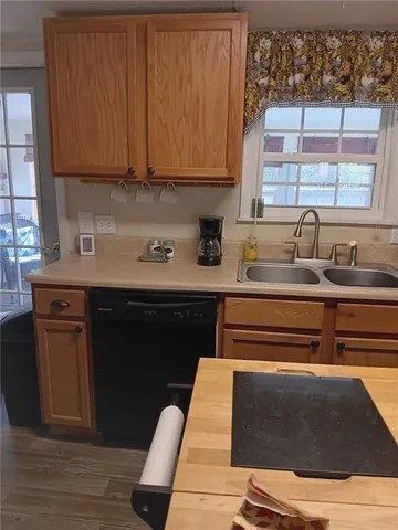 a kitchen with a sink cabinets and wooden floor