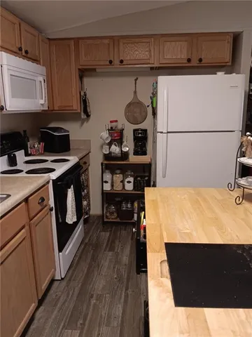 a kitchen with stainless steel appliances kitchen island granite countertop a stove a refrigerator and wooden cabinets