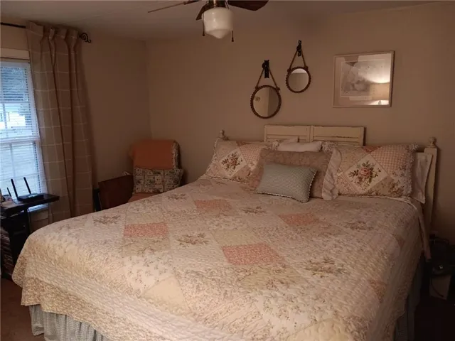 a bedroom with a bed and ceiling fan