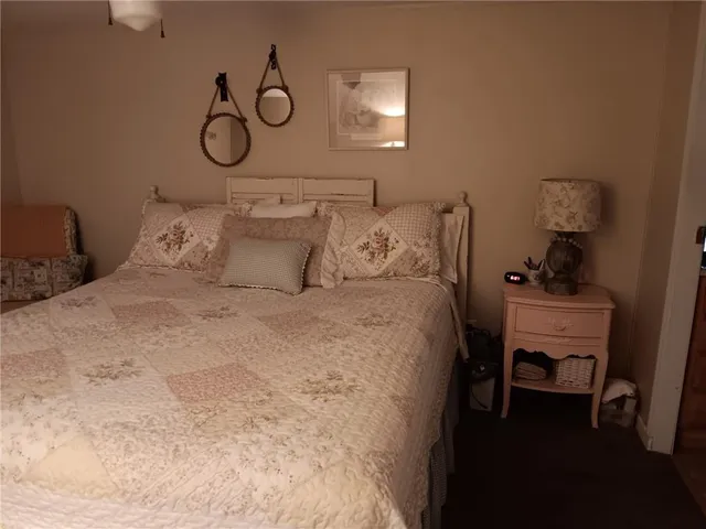 a bedroom with a bed and a lamp on dresser