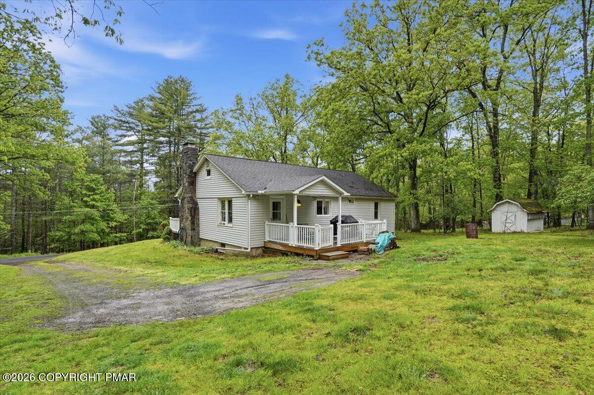 232 Garrity Road Hawley, PA 18428 - Photo 49 of 57 a house that is sitting in the grass with large trees and plants