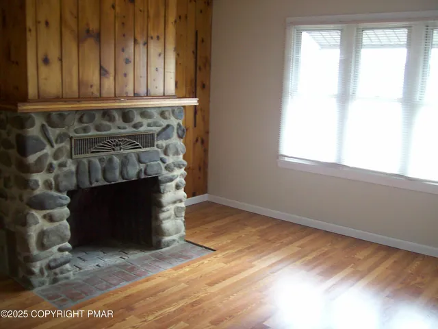 a view of a room with wooden floor and a fireplace