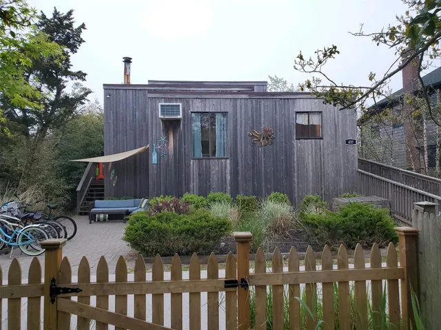 a view of a house with backyard and wooden fence