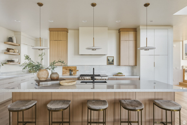 923 North Emery Lane Elk Ridge, UT 84651 - Photo 13 of 101 Spacious kitchen featuring a large island with seating, a gas range, integrated hood, and a combination of white and wood-finish cabinetry