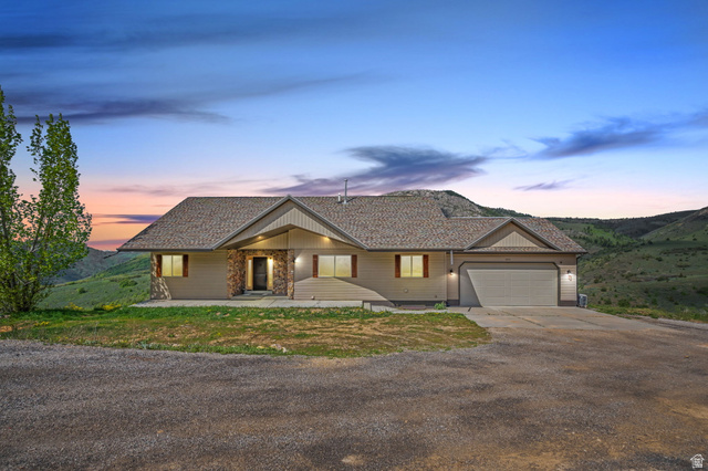Ranch-style home featuring concrete driveway and an attached garage