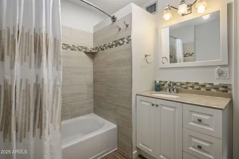 a bathroom with a granite countertop sink a toilet and shower