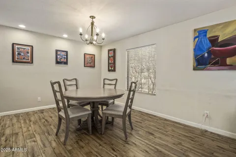 a view of a dining room with furniture a chandelier and wooden floor