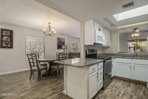 a kitchen with stainless steel appliances granite countertop a white cabinets and a stove