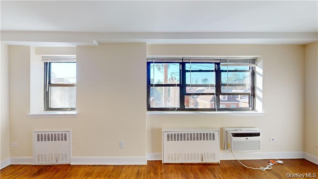 4200 Herkimer Place, Unit 4E Bronx, NY 10470 - Photo 7 of 8 Empty room featuring radiator heating unit, wood finished floors, and a wall unit AC