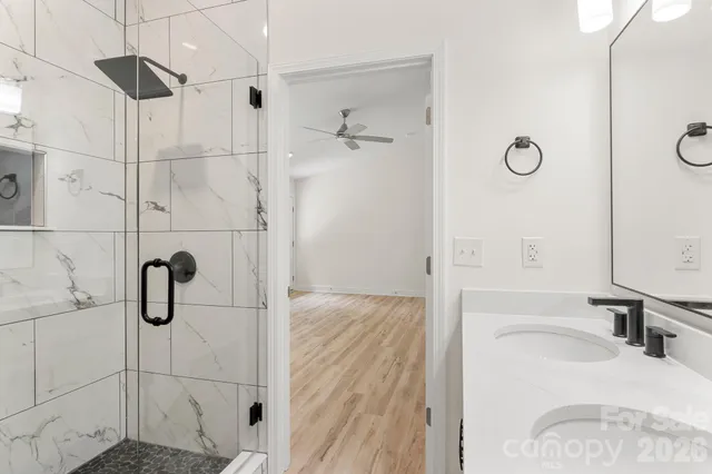 a view of empty room with wooden floor and fan