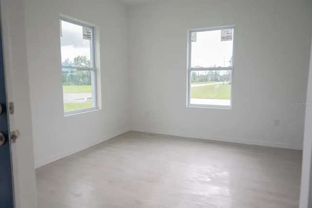 a large white kitchen with kitchen island a sink a stove a refrigerator and white cabinets