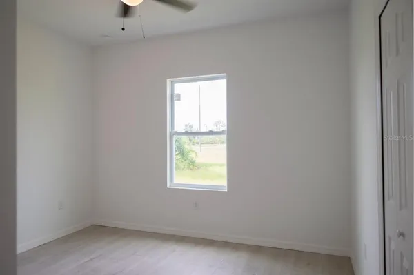 a view of a big room with wooden floor and windows