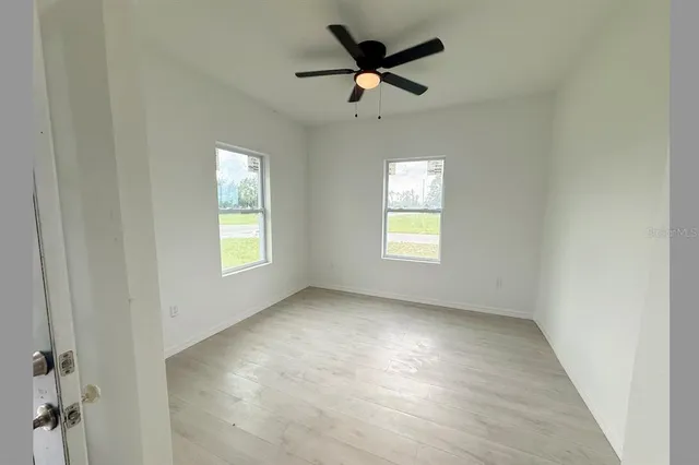 an empty room with windows and closet