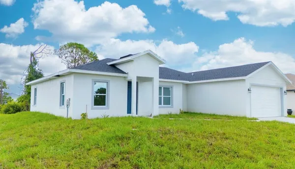 a view of a house with big yard and a large tree