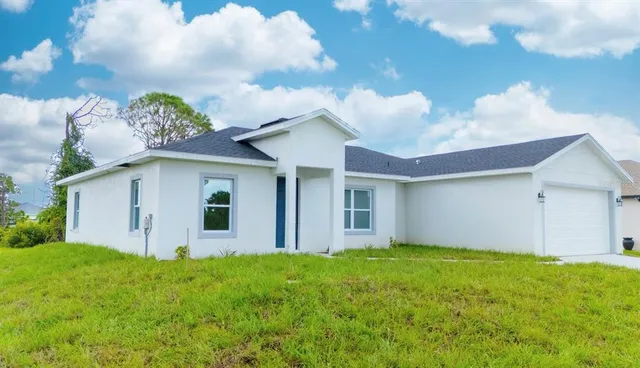 a view of a house with big yard and a large tree