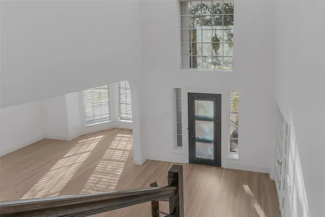 a view of a room that has wooden floor and white walls