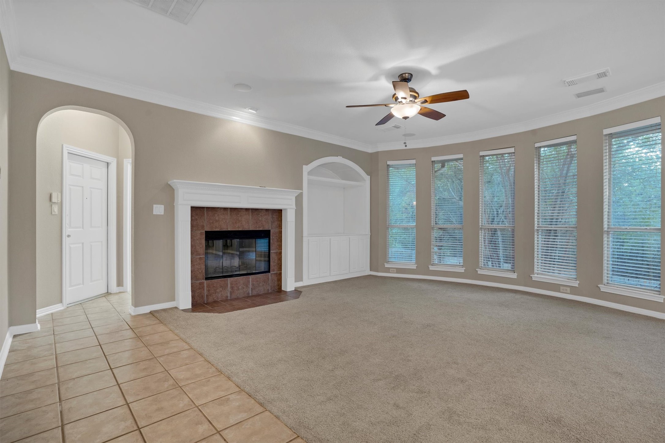 13013 Titus Court Austin, TX 78732 - Photo 11 of 30 a view of an empty room with chandelier fan and a fireplace
