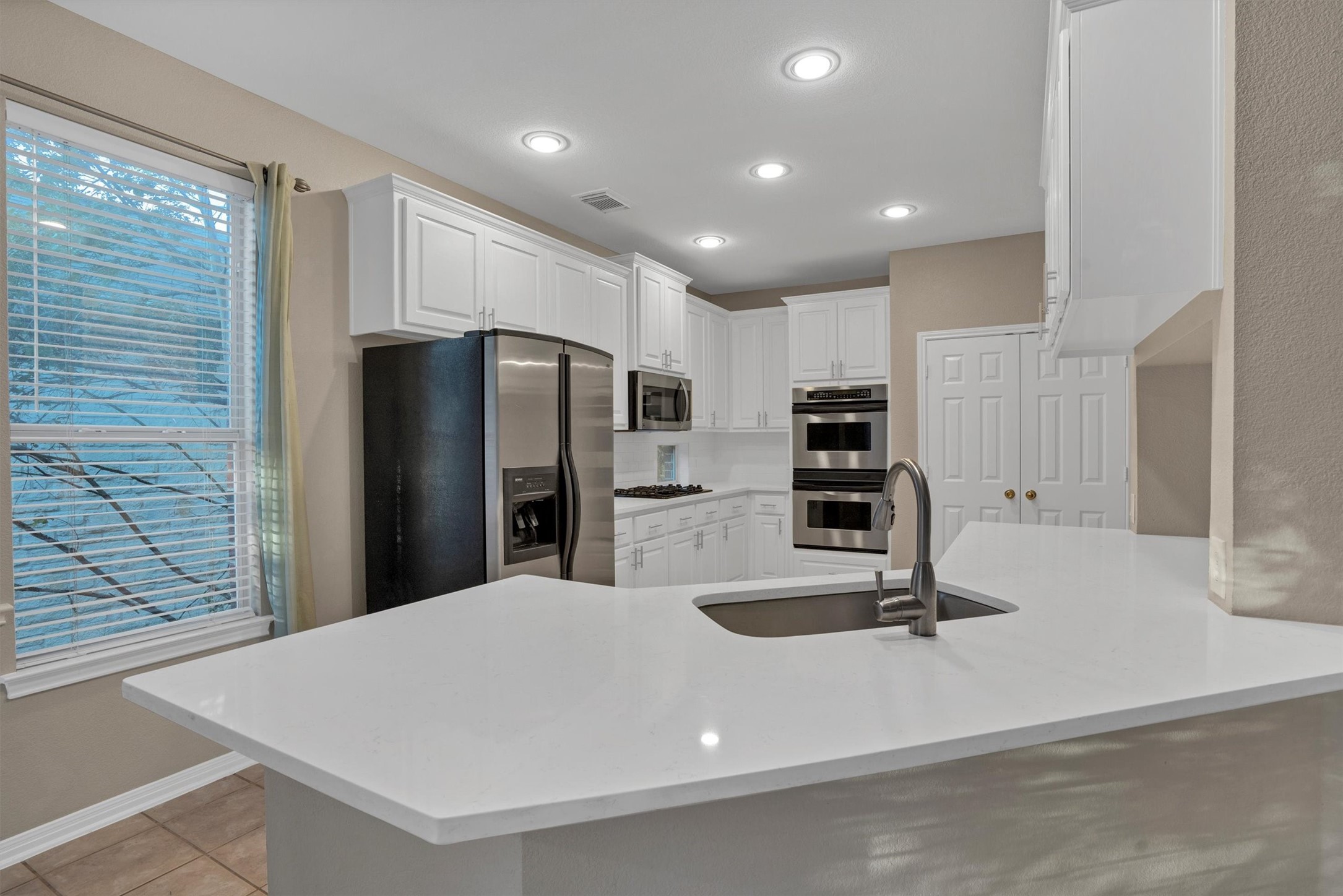 13013 Titus Court Austin, TX 78732 - Photo 7 of 30 a kitchen with stainless steel appliances a refrigerator and stove
