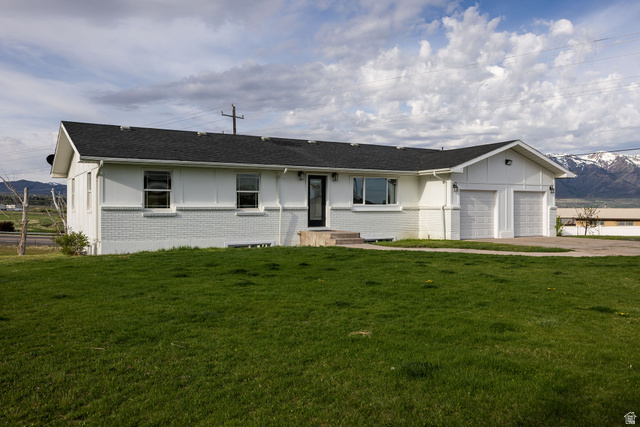 4155 Johnson Road Nibley, UT 84321 - Photo 4 of 71 Ranch-style house featuring a mountain view, brick siding, an attached garage, and a front yard