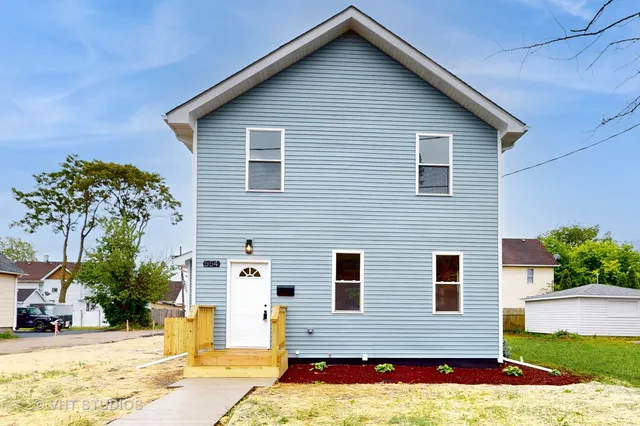 a view of a house with snow on the side of the road