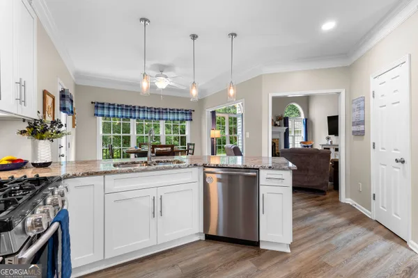 a kitchen with stainless steel appliances granite countertop a stove a sink and a microwave