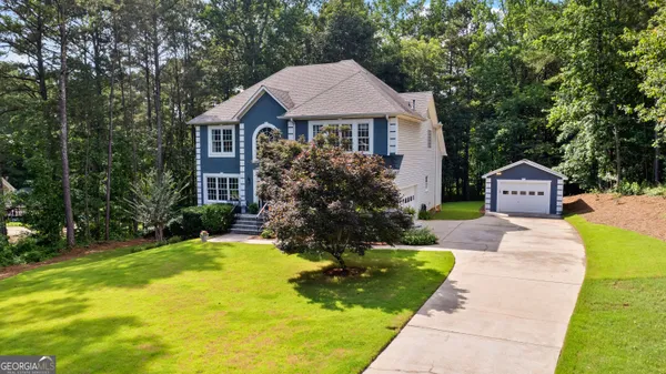 a front view of a house with a yard and trees