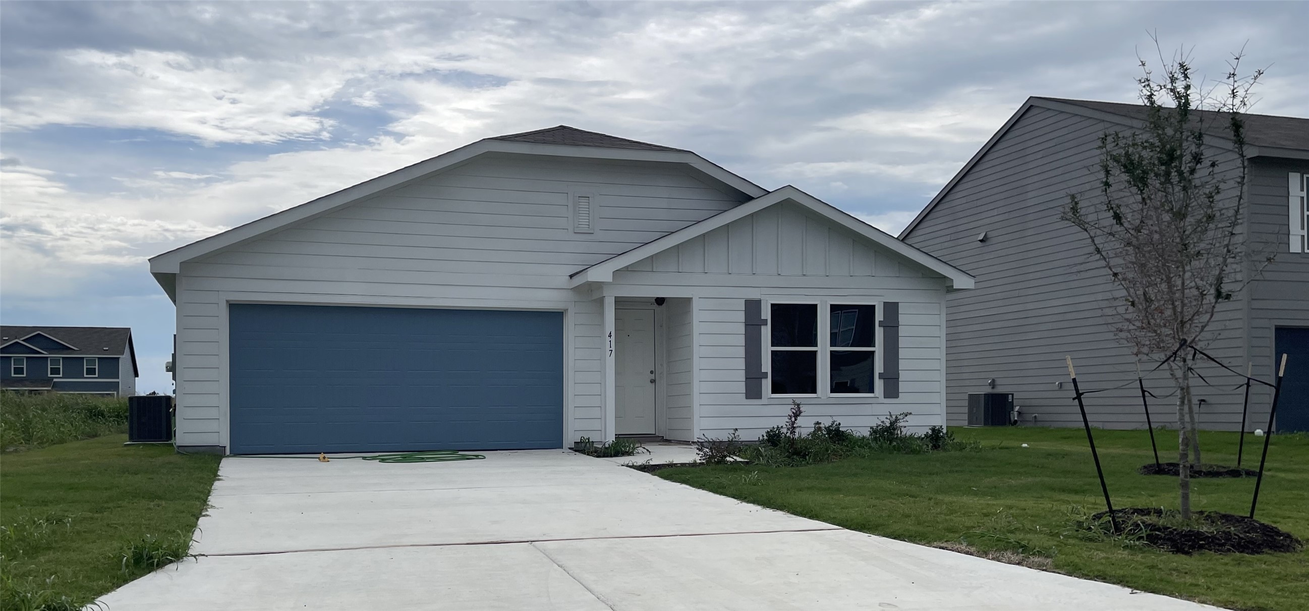 417 Rueben Avenue Holland, TX 76534 - Photo 1 of 1 View of front facade with board and batten siding, driveway, a front yard, and an attached garage
