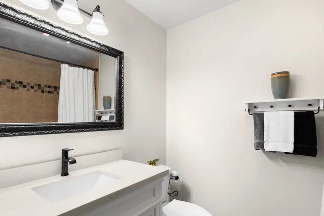 a bathroom with a sink a toilet and mirror