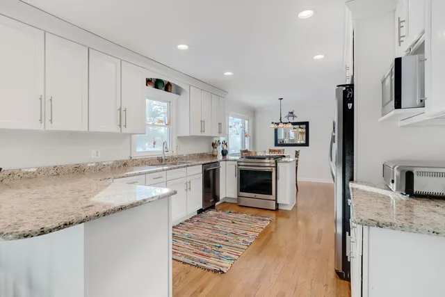 a kitchen with granite countertop a sink stove and refrigerator