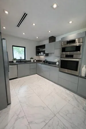 a large kitchen with stainless steel appliances granite countertop a stove and a refrigerator