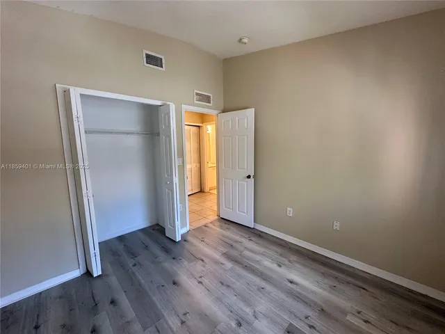 an empty room with wooden floor and closet