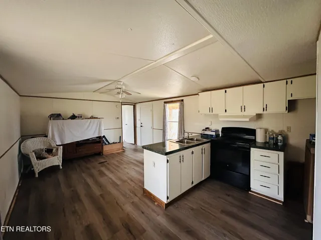 a kitchen with granite countertop a stove and a wooden floors