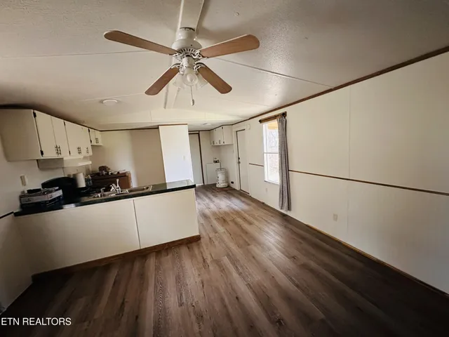 a kitchen with stainless steel appliances a refrigerator a sink and white cabinets