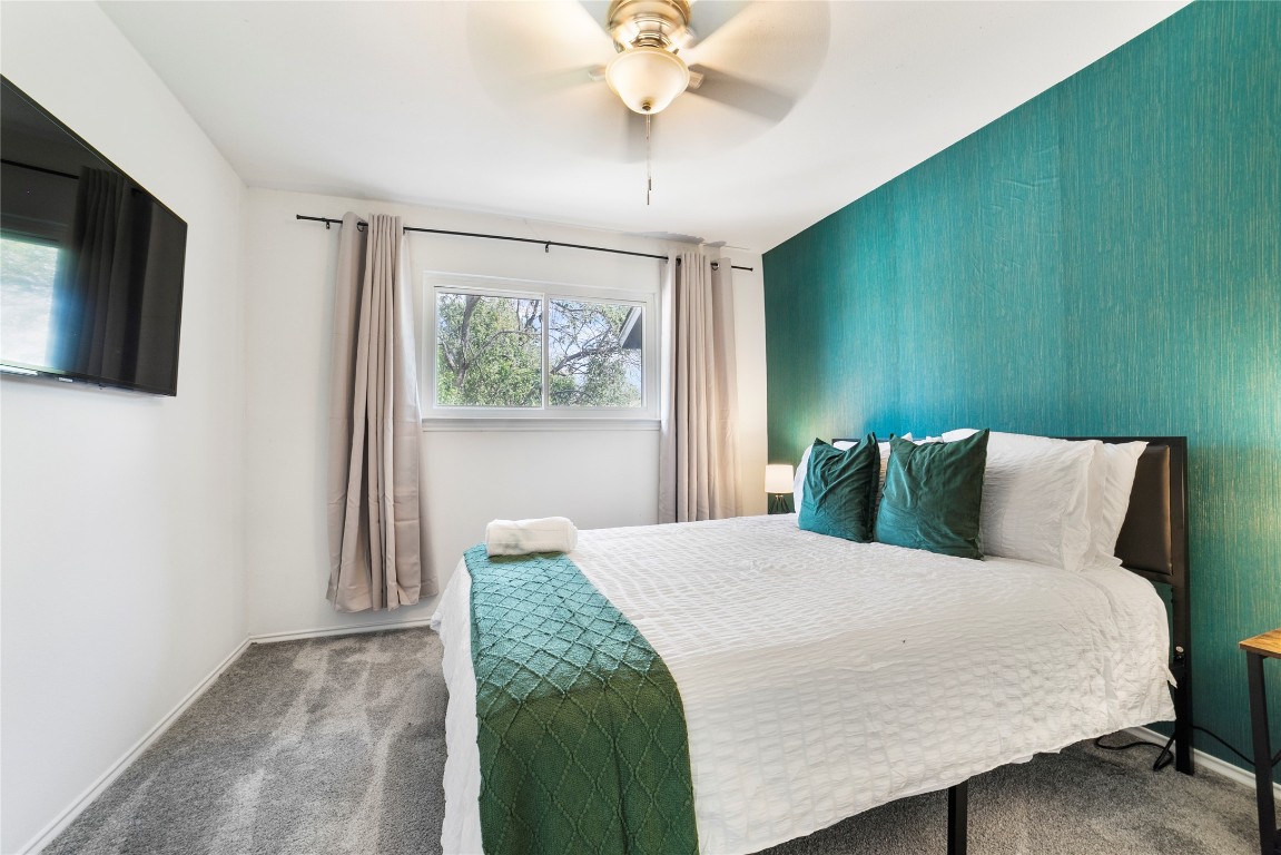 2009 Kenneth Avenue, Unit A Austin, TX 78741 - Photo 11 of 17 a bedroom with a bed and a chandelier